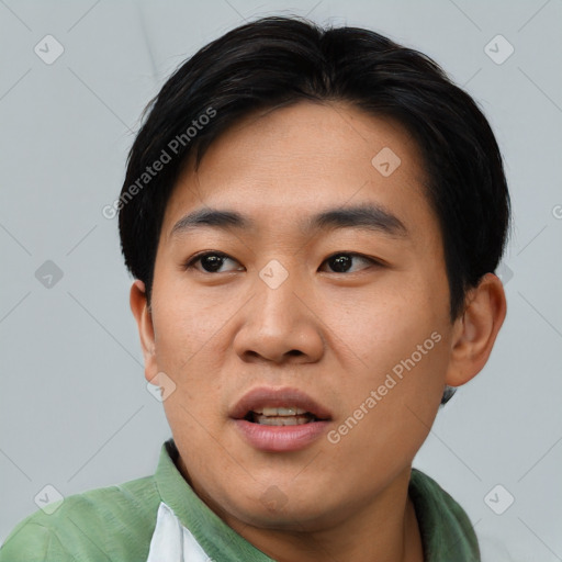 Joyful asian young-adult male with short  black hair and brown eyes