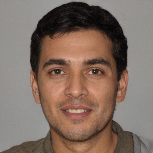Joyful white young-adult male with short  black hair and brown eyes