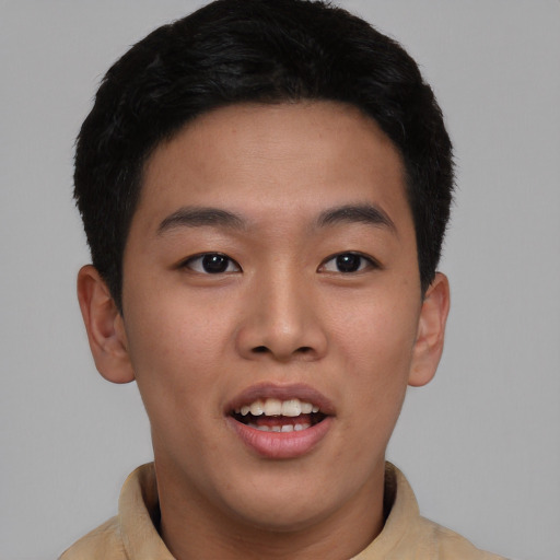 Joyful asian young-adult male with short  brown hair and brown eyes
