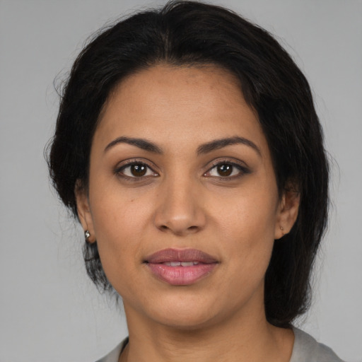 Joyful latino adult female with medium  black hair and brown eyes
