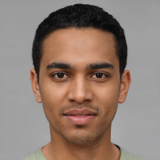 Joyful latino young-adult male with short  black hair and brown eyes