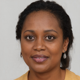 Joyful black adult female with long  brown hair and brown eyes