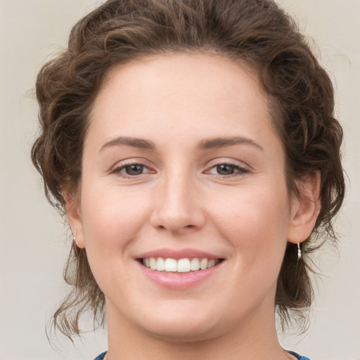 Joyful white young-adult female with medium  brown hair and green eyes