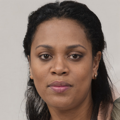 Joyful black adult female with long  black hair and brown eyes