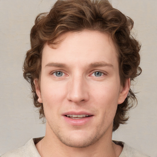 Joyful white young-adult male with short  brown hair and blue eyes