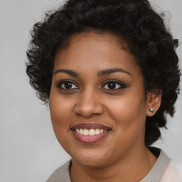 Joyful black young-adult female with long  brown hair and brown eyes