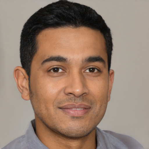 Joyful latino young-adult male with short  black hair and brown eyes