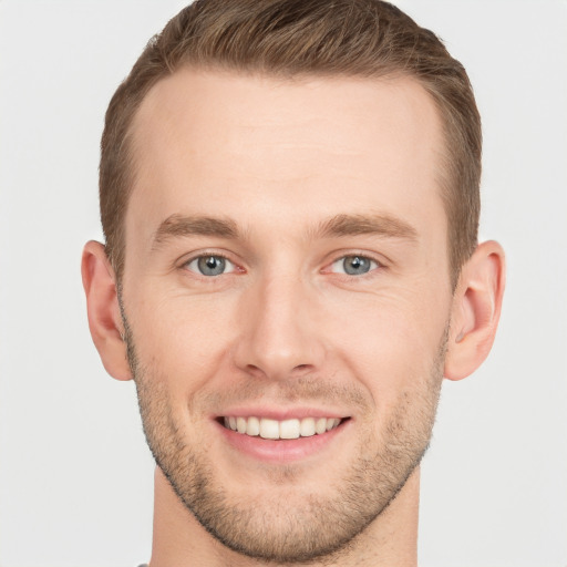 Joyful white young-adult male with short  brown hair and grey eyes