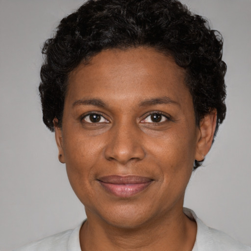 Joyful black adult female with short  brown hair and brown eyes