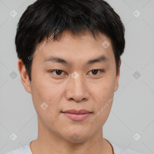 Joyful asian young-adult male with short  brown hair and brown eyes