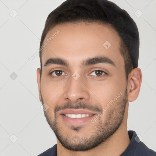 Joyful white young-adult male with short  black hair and brown eyes