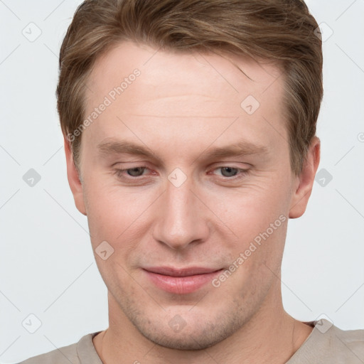 Joyful white young-adult male with short  brown hair and grey eyes