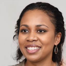 Joyful black young-adult female with long  brown hair and brown eyes