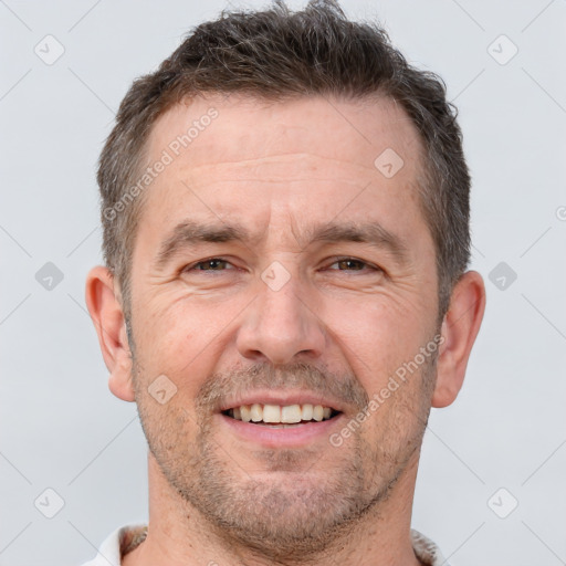 Joyful white adult male with short  brown hair and brown eyes