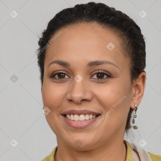 Joyful black young-adult female with long  brown hair and brown eyes