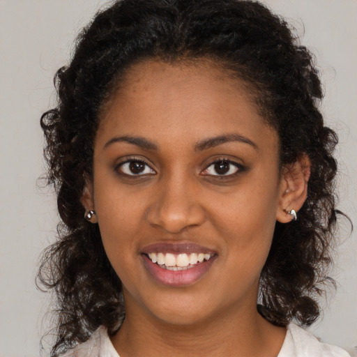 Joyful black young-adult female with long  brown hair and brown eyes