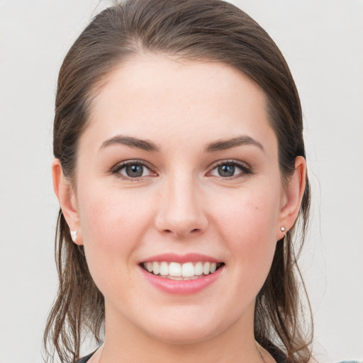 Joyful white young-adult female with medium  brown hair and grey eyes