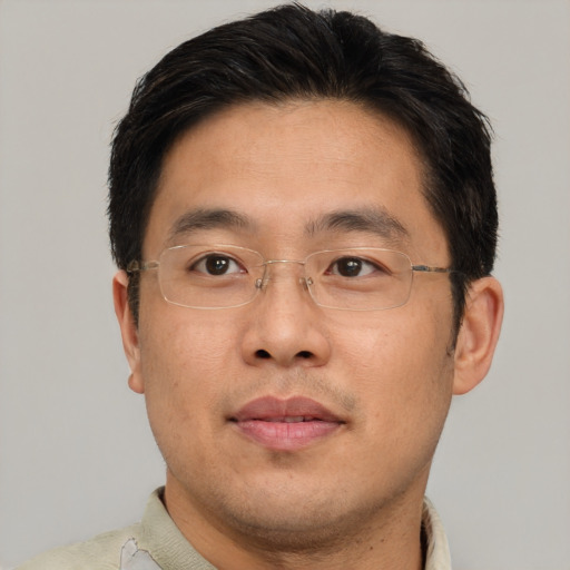 Joyful asian adult male with short  brown hair and brown eyes