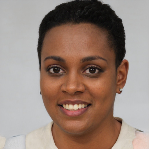 Joyful black young-adult female with short  black hair and brown eyes