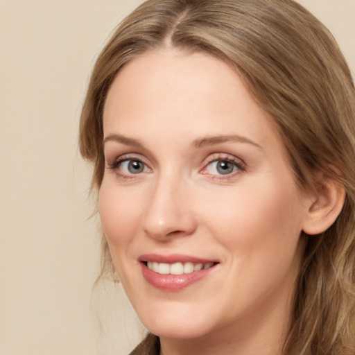 Joyful white young-adult female with long  brown hair and blue eyes