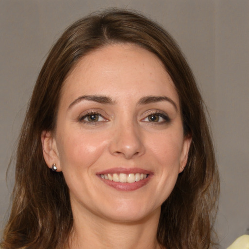 Joyful white young-adult female with long  brown hair and brown eyes