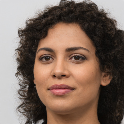 Joyful latino young-adult female with medium  brown hair and brown eyes