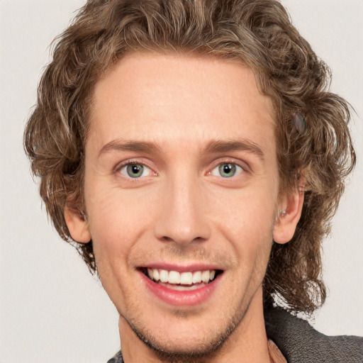 Joyful white young-adult male with short  brown hair and blue eyes