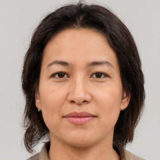 Joyful asian adult female with medium  brown hair and brown eyes