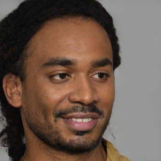 Joyful black young-adult male with short  black hair and brown eyes