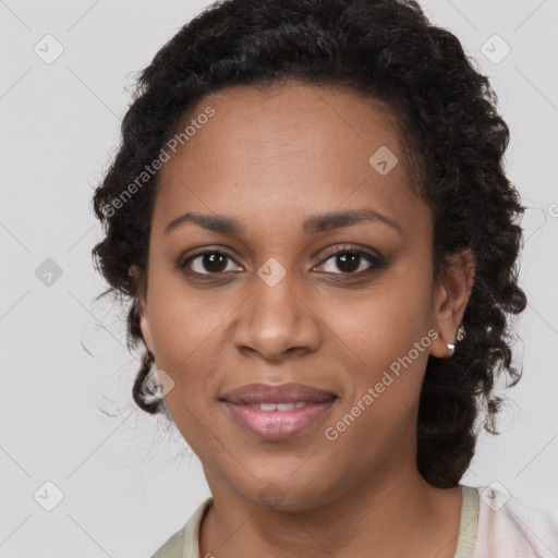 Joyful black young-adult female with long  brown hair and brown eyes