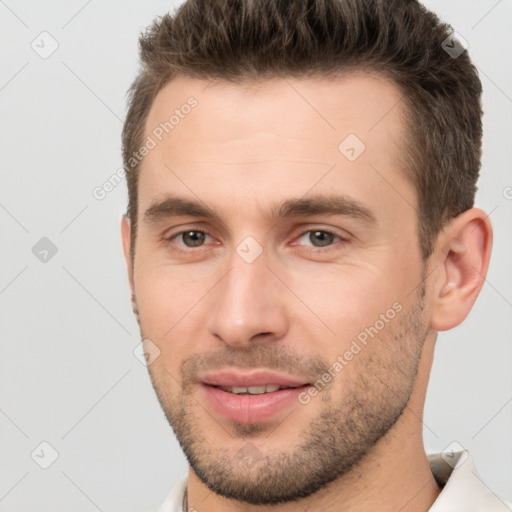 Joyful white young-adult male with short  brown hair and brown eyes