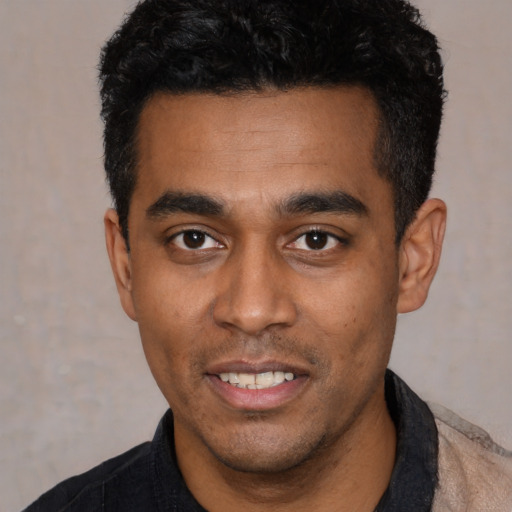 Joyful latino young-adult male with short  black hair and brown eyes