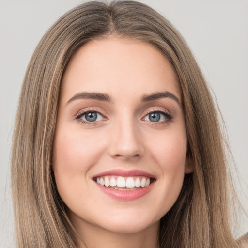 Joyful white young-adult female with long  brown hair and green eyes