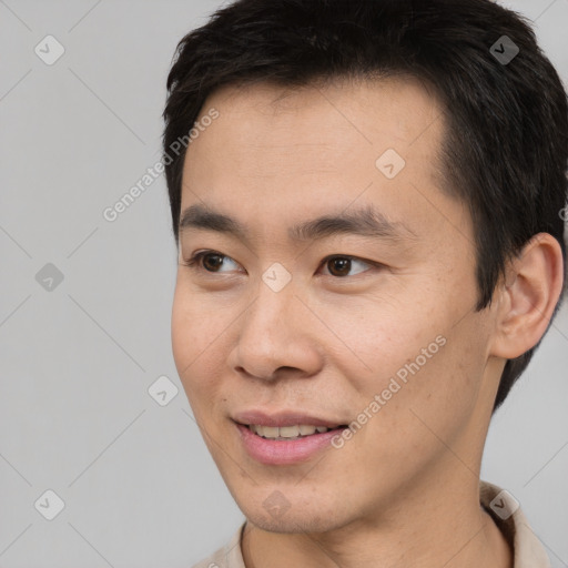 Joyful asian young-adult male with short  brown hair and brown eyes