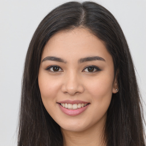 Joyful latino young-adult female with long  brown hair and brown eyes