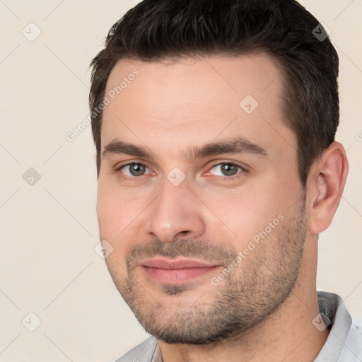 Joyful white young-adult male with short  brown hair and brown eyes