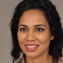 Joyful latino young-adult female with long  brown hair and brown eyes