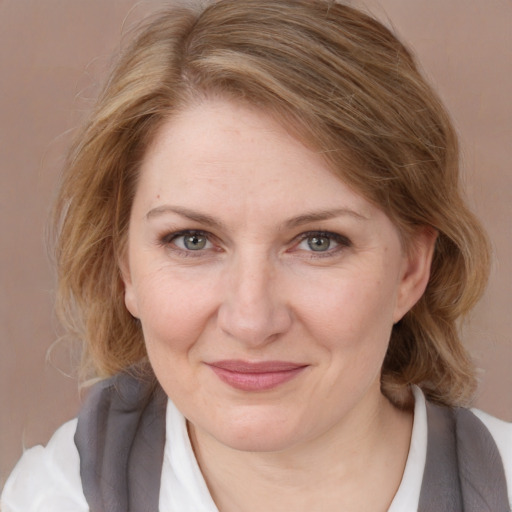 Joyful white adult female with medium  brown hair and blue eyes