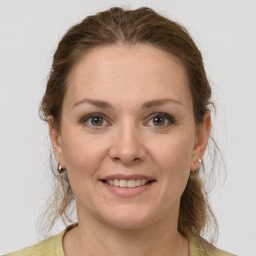 Joyful white young-adult female with medium  brown hair and grey eyes