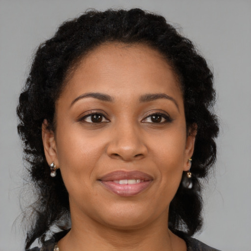 Joyful latino adult female with medium  brown hair and brown eyes