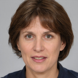 Joyful white adult female with medium  brown hair and grey eyes