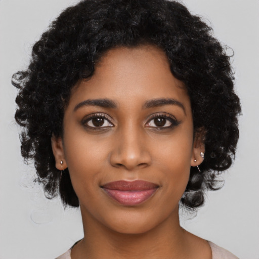 Joyful black young-adult female with long  black hair and brown eyes