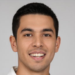 Joyful latino young-adult male with short  brown hair and brown eyes