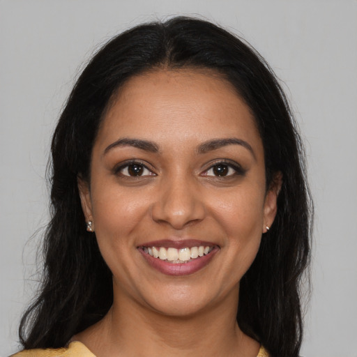 Joyful latino young-adult female with long  brown hair and brown eyes