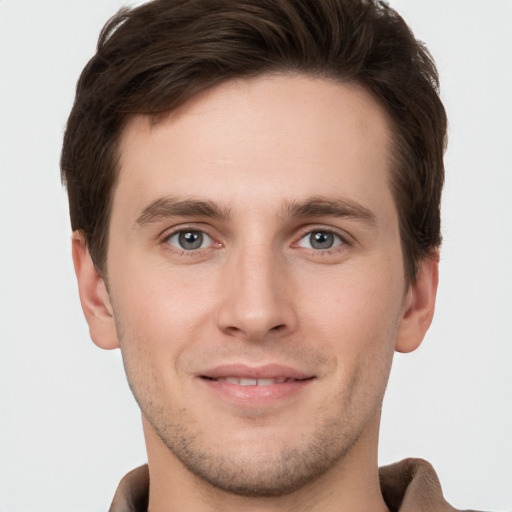 Joyful white young-adult male with short  brown hair and grey eyes