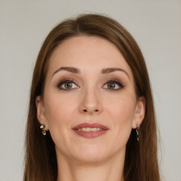 Joyful white young-adult female with long  brown hair and grey eyes