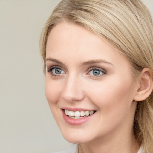 Joyful white young-adult female with long  brown hair and blue eyes