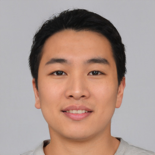 Joyful asian young-adult male with short  black hair and brown eyes