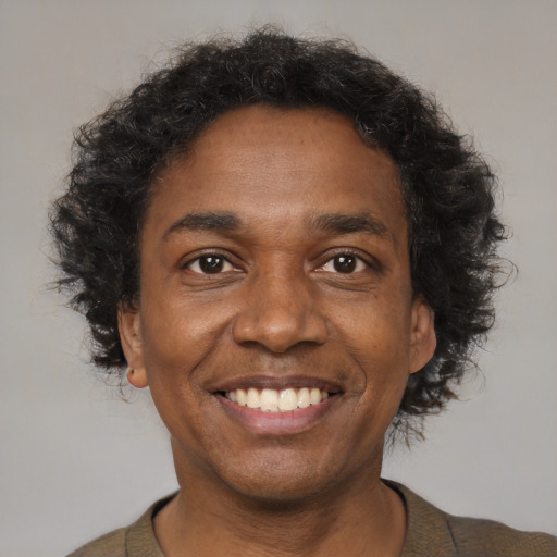 Joyful black adult male with short  brown hair and brown eyes