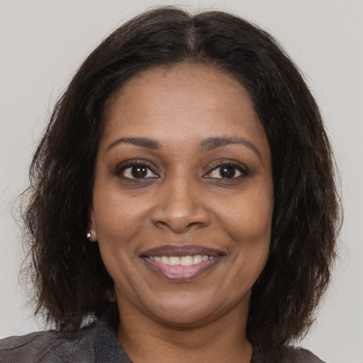 Joyful black young-adult female with medium  brown hair and brown eyes